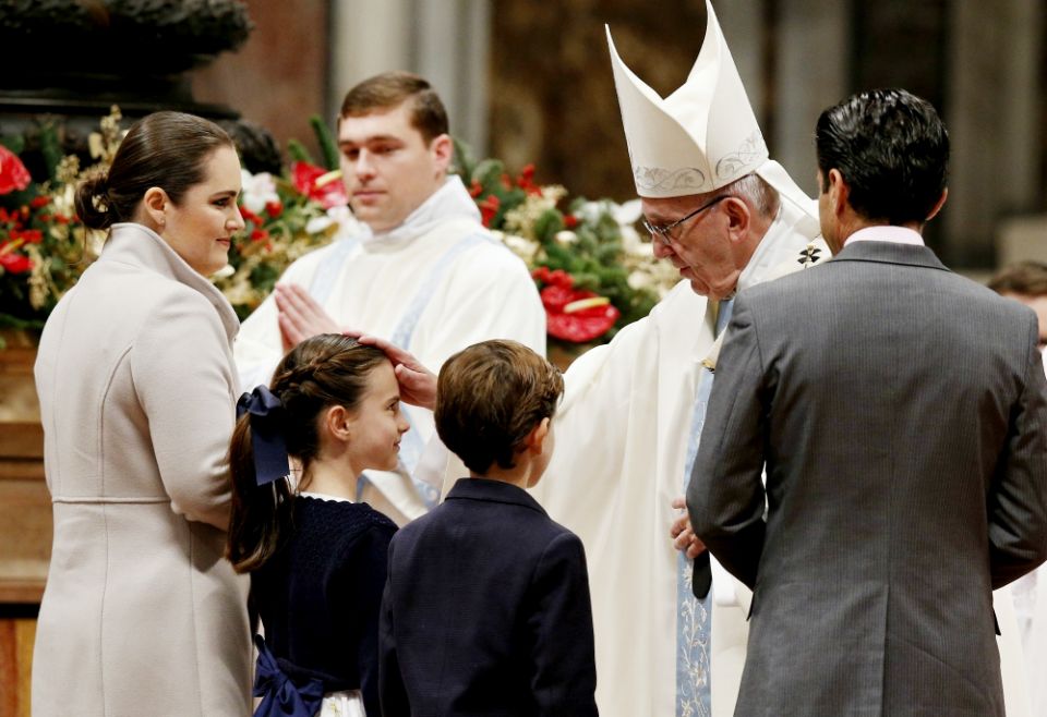 Pope Francis greets a family as they present offertory gifts during a Mass marking the feast of Mary, Mother of God, in St. Peter's Basilica at the Vatican Jan. 1, 2017. (CNS/Paul Haring)
