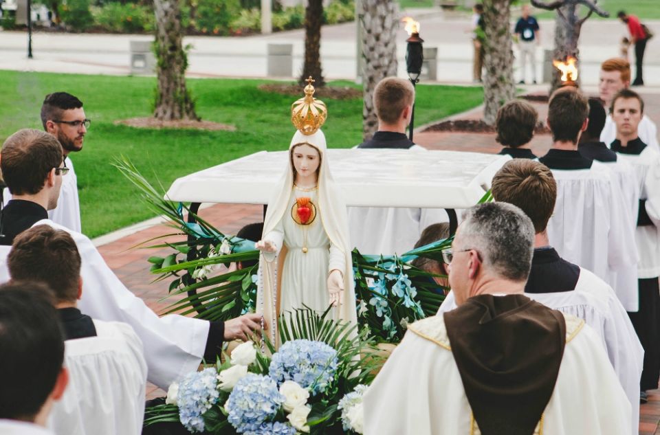 Clergymen walk with a statue of Mary during a June 13, 2017, procession in Ave Maria, Florida, during a ceremony to consecrate the Fellowship of Catholic University Students, or FOCUS, to Mary. (CNS/Courtesy of FOCUS)