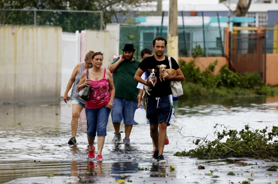 People walk in a flooded street Sept. 21 in Toa Baja, Puerto Rico, in the aftermath of Hurricane Maria. (CNS/EPA/Thais Llorca)