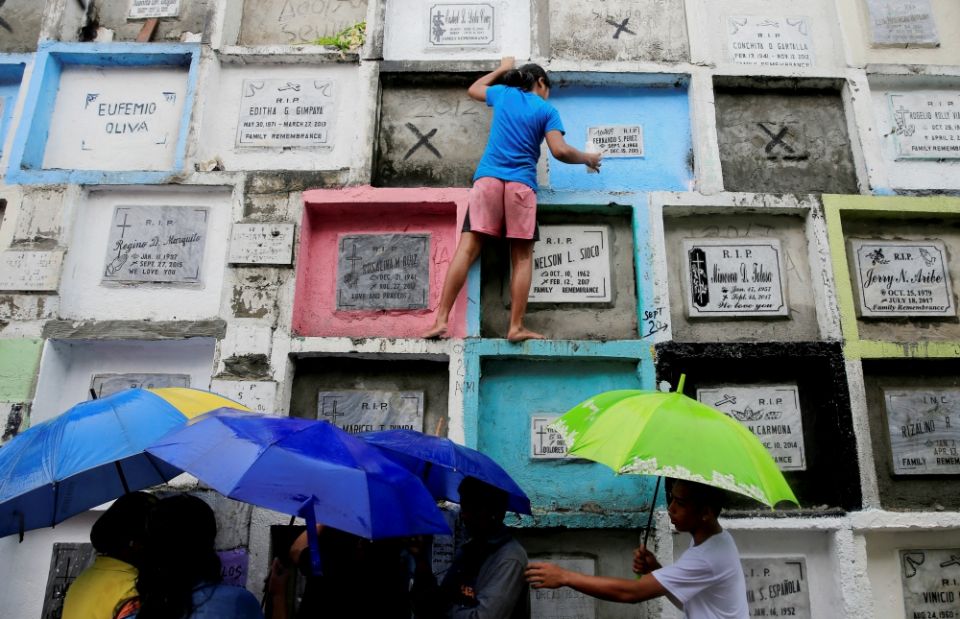 People visit tombs inside a public cemetery in Manila, Philippines, Nov. 1. On All Saints' Day and All Souls' Day Nov. 1 and 2, cemeteries across the country are crowded with people paying their respects to departed loved ones. (CNS/Reuters/Romeo Ranoco)