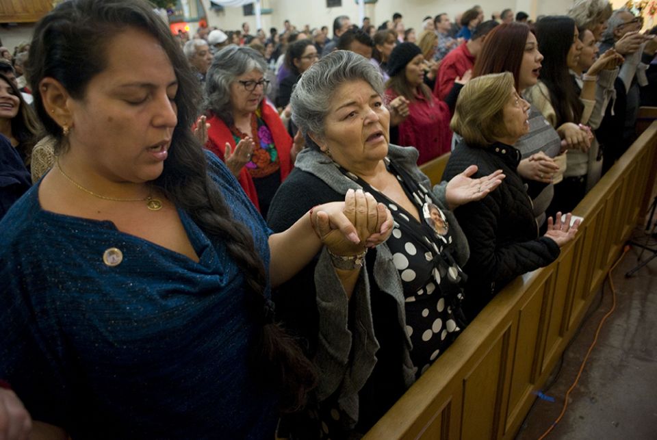 Worshippers recite the Lord's Prayer during a Mass celebrated in honor of the 100th anniversary of Our Lady of Guadalupe Church Dec. 9, 2017, in San Diego. The church was first founded to serve the recently arrived Mexican population in San Diego, and has