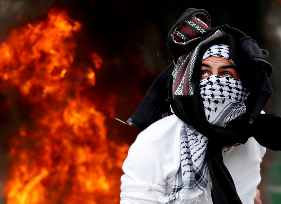 A Palestinian throws a stone at Israeli forces near Ramallah, West Bank, during a Dec. 20 protest against U.S. President Donald Trump's decision to recognize Jerusalem as the capital of Israel. (CNS/Reuters/Goran Tomasevic) A Palestinian throws a stone at Israeli forces near Ramallah, West Bank, during a Dec. 20 protest against U.S. President Donald Trump's decision to recognize Jerusalem as the capital of Israel. (CNS/Reuters/Goran Tomasevic)