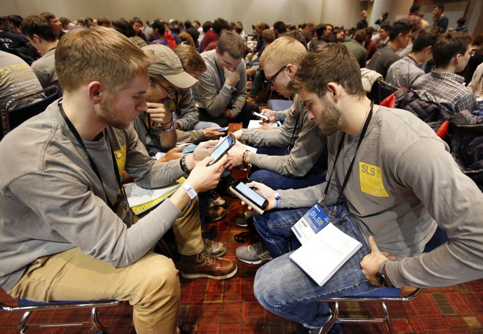 Students from the Diocese of Toledo, Ohio, look up Scripture passages on their cellphones during a group discussion Jan. 3 at a conference sponsored by the Fellowship of Catholic University Students in Chicago. (CNS/Karen Callaway, Chicago Catholic)