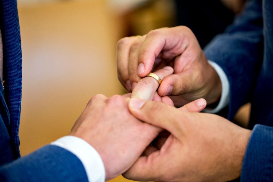 Two same-sex partners exchange wedding bands during a 2017 ceremony at the civil registry office in Munich. (CNS/EPA/Marc Mueller)