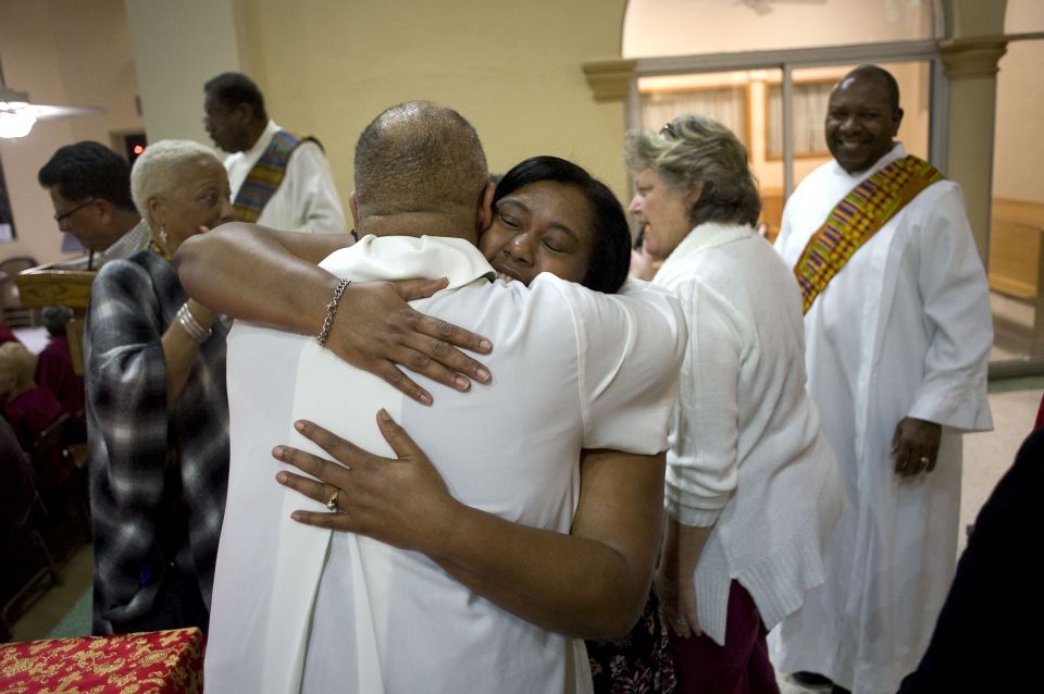 Worshippers exchange the sign of peace on the second evening of an African-American Catholic revival celebration Feb. 6 at St. Rita's Catholic Church in San Diego. (CNS/David Maung)