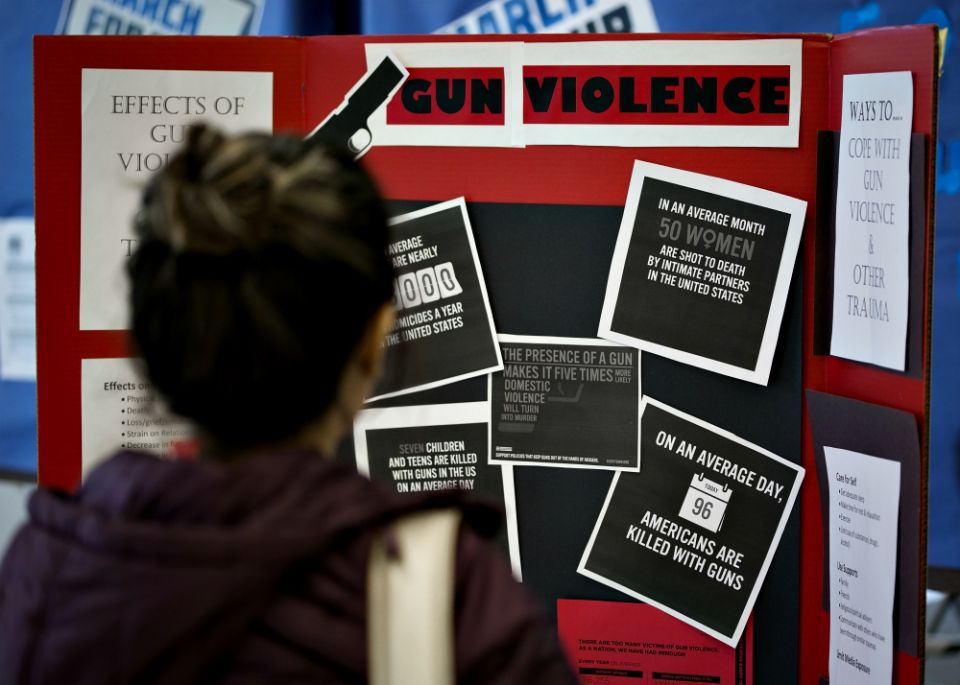 A person reads information about gun violence during a panel discussion about gun policy analysis and citizen activism at Trinity Washington University March 23. (CNS/Tyler Orsburn)