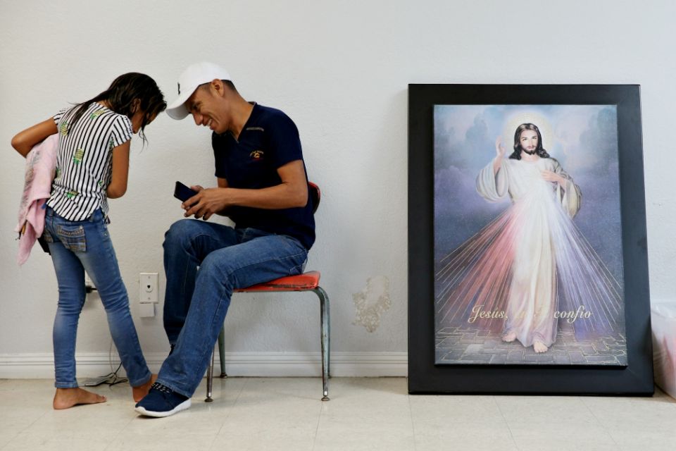 A Guatemalan immigrant and his daughter, recently released from detention through the U.S. immigration policy called "catch and release," talk with each other April 14 at the Catholic Charities relief center in McAllen, Texas. (CNS/Reuters/Loren Elliott) A Guatemalan immigrant and his daughter, recently released from detention through the U.S. immigration policy called "catch and release," talk with each other April 14 at the Catholic Charities relief center in McAllen, Texas. (CNS/Reuters/Loren Elliott)