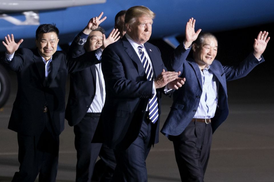 President Donald Trump walks with three U.S. detainees arriving May 10 at Joint Base Andrews, Maryland, after they were released by North Korea as a goodwill gesture. (CNS/EPA/Michael Reynolds)