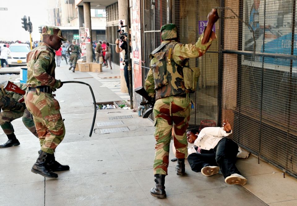 Soldiers beat a female supporter of the MDC Alliance opposition party of Nelson Chamisa outside the party's headquarters as they await the results of the general elections Aug. 1 in Harare, Zimbabwe. (CNS/Reuters/Mike Hutchings)
