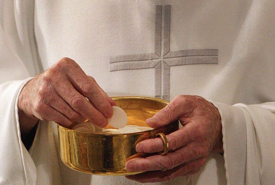 A priest prepares to distribute Communion during Mass in Washington. (CNS/Bob Roller) A priest prepares to distribute Communion during Mass in Washington. (CNS/Bob Roller)