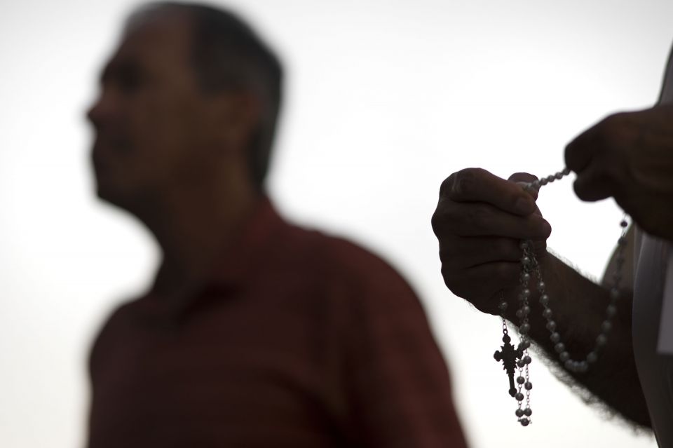 An attendee prays the rosary Oct. 1 during a public session on the issue of clergy sexual abuse at Our Mother of Confidence Parish Hall in San Diego. (CNS/David Maung) An attendee prays the rosary Oct. 1 during a public session on the issue of clergy sexual abuse at Our Mother of Confidence Parish Hall in San Diego. (CNS/David Maung)