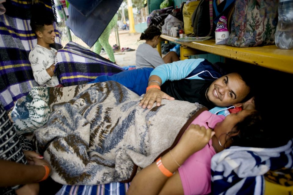 Tomas Torres puts his hand on the stomach of his pregnant wife, Elvia Perez de Torres, as they rest at a camp for migrants at a sports facility in Tijuana, Mexico. (CNS/David Maung) Tomas Torres puts his hand on the stomach of his pregnant wife, Elvia Perez de Torres, as they rest at a camp for migrants at a sports facility in Tijuana, Mexico. (CNS/David Maung)