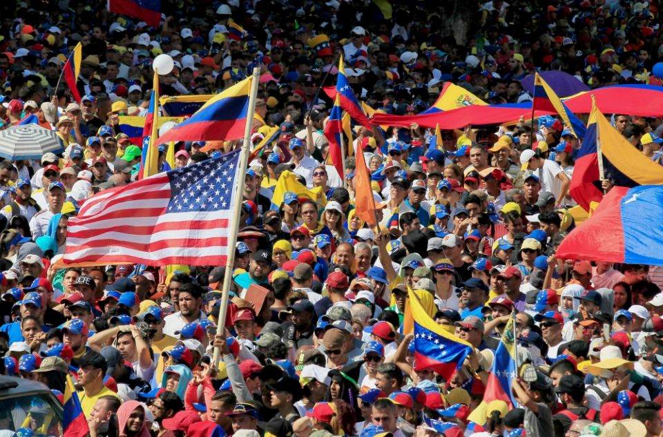 A U.S. flag waves in the crowd as protesters take part in a rally against Venezuelan President Nicolás Maduro's government in Maracaibo Jan. 23. (CNS/Reuters/Isaac Urrutia)