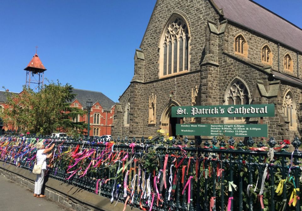 A woman puts a ribbon on the fence of St. Patrick's Cathedral in Ballarat, Australia, in February 2019. The ribbons raise awareness and show support for victims of abuse. (CNS/Reuters/Jonathan Barrett) A woman puts a ribbon on the fence of St. Patrick's Cathedral in Ballarat, Australia, in February 2019. The ribbons raise awareness and show support for victims of abuse. (CNS/Reuters/Jonathan Barrett)