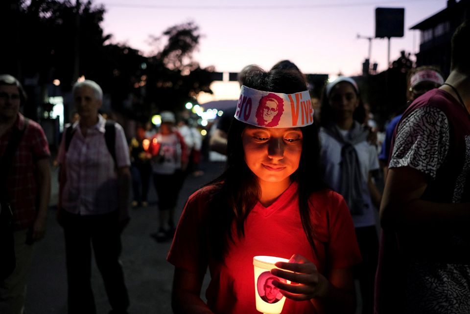 A woman holds a candle during a March 23, 2019, procession to commemorate the 39th anniversary of the murder of St. Oscar Romero in San Salvador, El Salvador. (CNS/Jose Cabezas, Reuters)