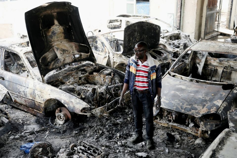 Nigerian entrepreneur Basil Onibo, one of the victims of a recent spate of xenophobic attacks in South Africa, looks at the burned cars at his dealership in Johannesburg Sept. 5. (CNS/Reuters/Siphiwe Sibeko)