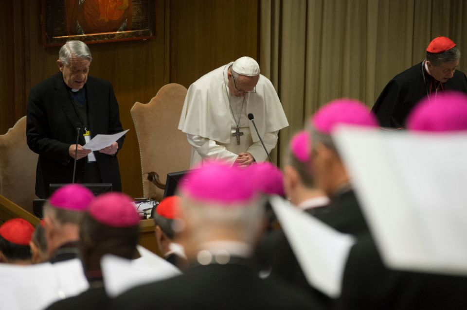 Pope Francis prays during the February 2019 Vatican meeting on the protection of minors. On the left is Jesuit Fr. Federico Lombardi. On the right is Chicago Cardinal Blase Cupich. (CNS/Reuters/Vatican Media)