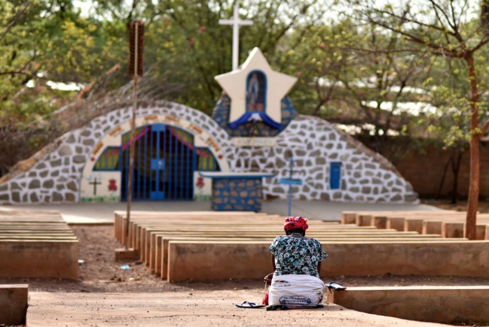 A displaced Christian woman prays in front of a grotto with a statue of Mary in Kaya, Burkina Faso, May 16, 2019. (CNS/Reuters/Anne Mimault)