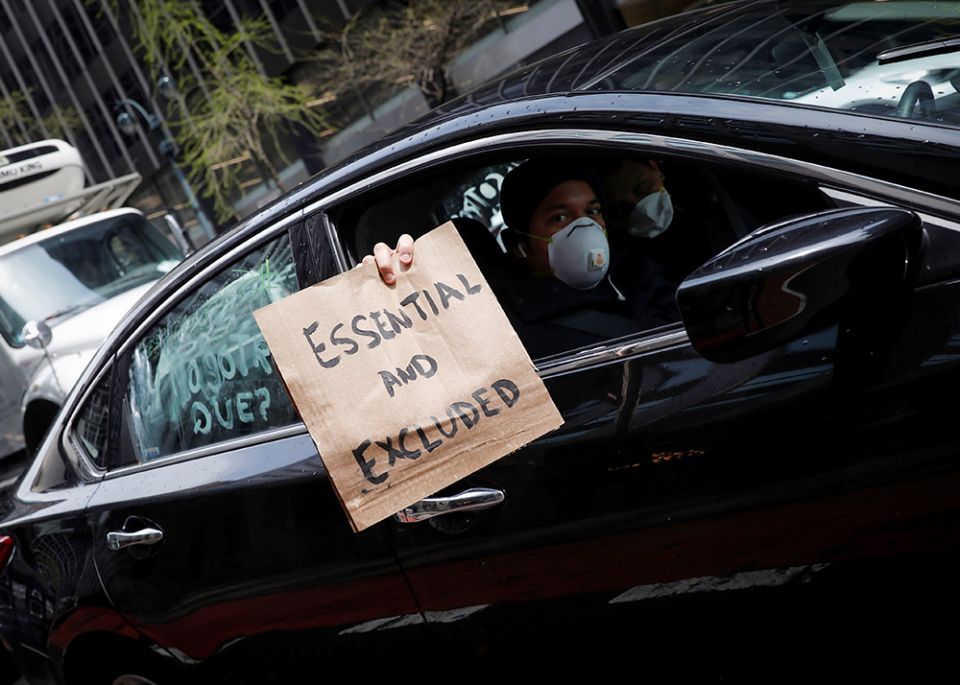 A worker in New York City holds a sign from a car during a caravan demonstration for the rights of essential immigrant workers April 21, 2020. (CNS/Reuters/Mike Segar)