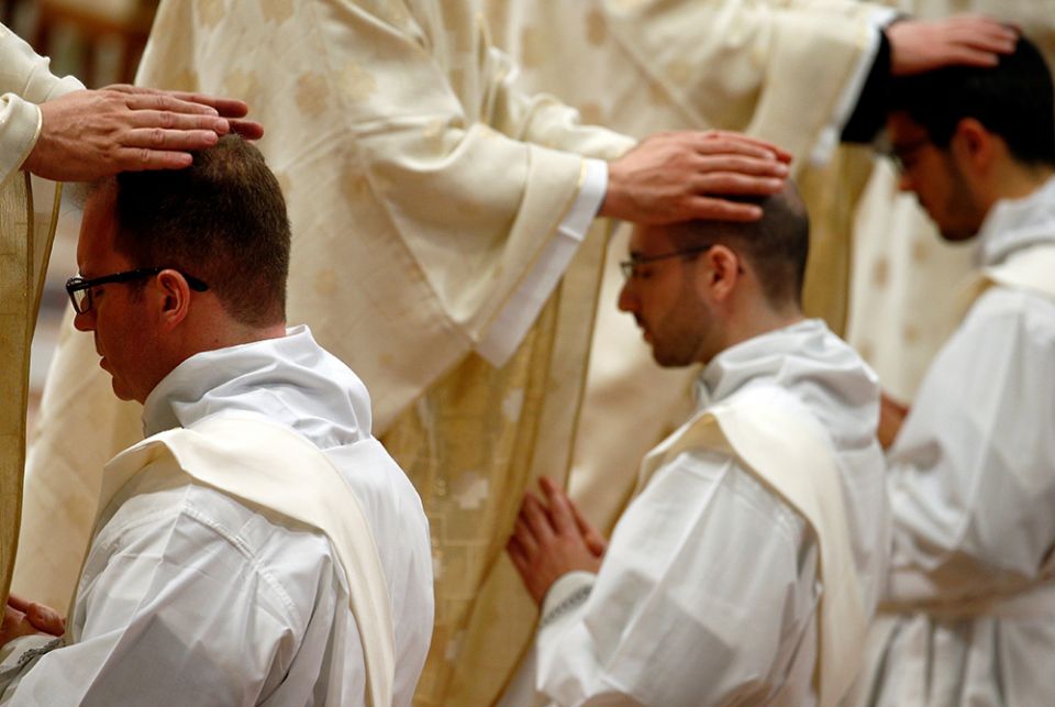 Newly ordained priests Priests put their hands on the heads of newly ordained priests during an ordination Mass celebrated by Pope Francis May 12, 2019, in St. Peter's Basilica at the Vatican. (CNS/Reuters/Yara Nardi)
