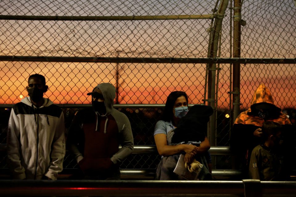 Migrants in the "Remain in Mexico" program line up at the Paso del Norte Mexico-U.S. border bridge in Ciudad Juarez, Mexico, April 21 to reschedule their United States immigration hearings during the coronavirus pandemic. (CNS/Reuters/Jose Luis Gonzalez) Migrants in the "Remain in Mexico" program line up at the Paso del Norte Mexico-U.S. border bridge in Ciudad Juarez, Mexico, April 21 to reschedule their United States immigration hearings during the coronavirus pandemic. (CNS/Reuters/Jose Luis Gonzalez)