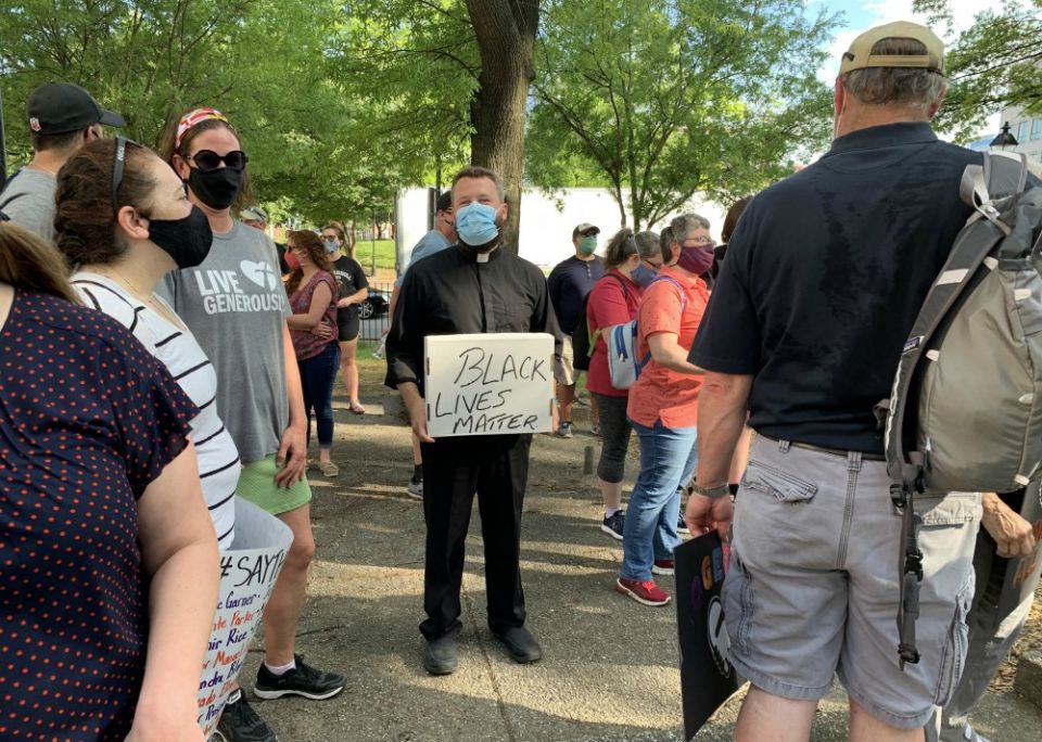 Fr. Joshua Laws, pastor of the Catholic Community of South Baltimore, holds a "Black Lives Matter" sign before the start of an interfaith prayer vigil in Baltimore June 3 to pray for justice and peace following the May 25 death of George Floyd. (CNS) Fr. Joshua Laws, pastor of the Catholic Community of South Baltimore, holds a "Black Lives Matter" sign before the start of an interfaith prayer vigil in Baltimore June 3 to pray for justice and peace following the May 25 death of George Floyd. (CNS)