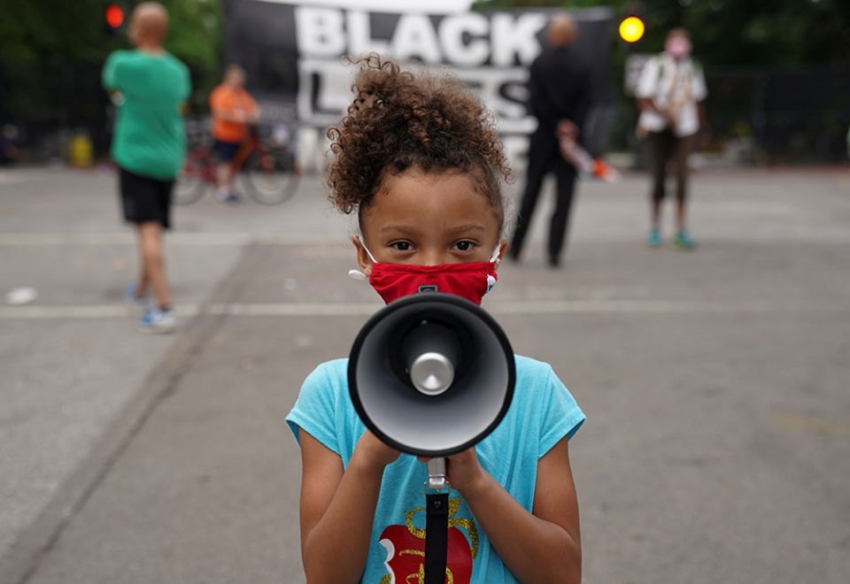 Mischa, 6, from Maryland, holds a bullhorn in front of a "Black Lives Matter" protest sign near the White House in Washington June 10, 2020. (CNS/Reuters/Kevin Lamarque)
