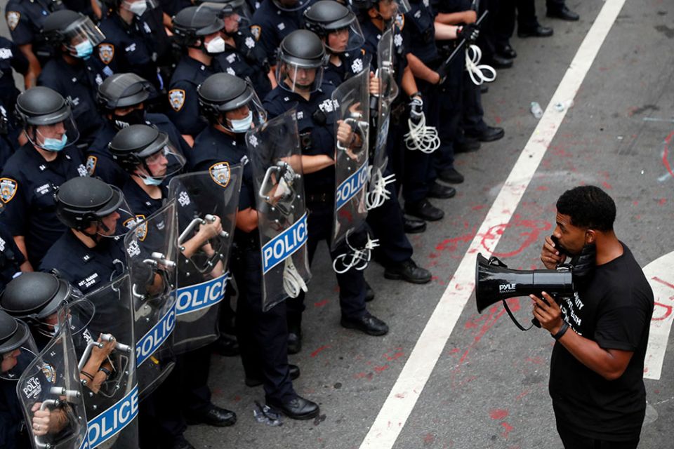 A demonstrator with Black Lives Matter stands in front of police officers in New York City inside of an area called the "City Hall Autonomous Zone" July 1. (CNS/Reuters/Andrew Kelly) A demonstrator with Black Lives Matter stands in front of police officers in New York City inside of an area called the "City Hall Autonomous Zone" July 1. (CNS/Reuters/Andrew Kelly)