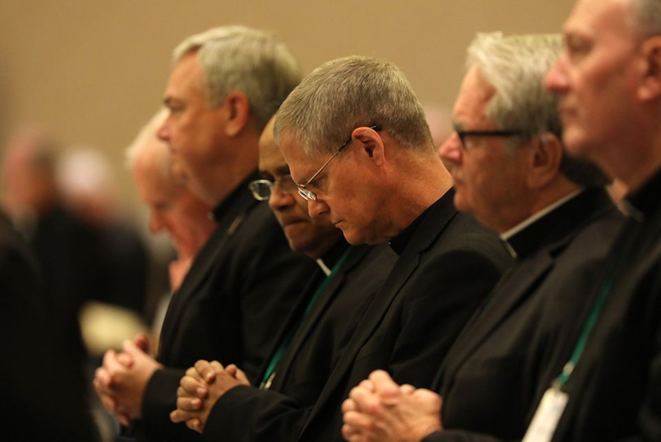 Archbishop Paul Etienne of Seattle, center, and other prelates pray during the fall general assembly of the U.S. Conference of Catholic Bishops Nov. 12, 2019, in Baltimore. (CNS)