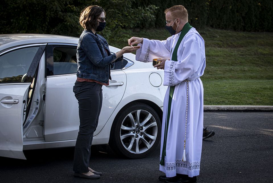 Fr. Mark Searles wears a mask while giving Communion to a parishioner Fr. Mark Searles, a resident priest at St. Thomas More Catholic Church in Allentown, Pennsylvania, wears a mask while giving Communion to a parishioner following an Oct. 2, 2020, Mass celebrated in the parish parking lot. (CNS/Chaz Muth)