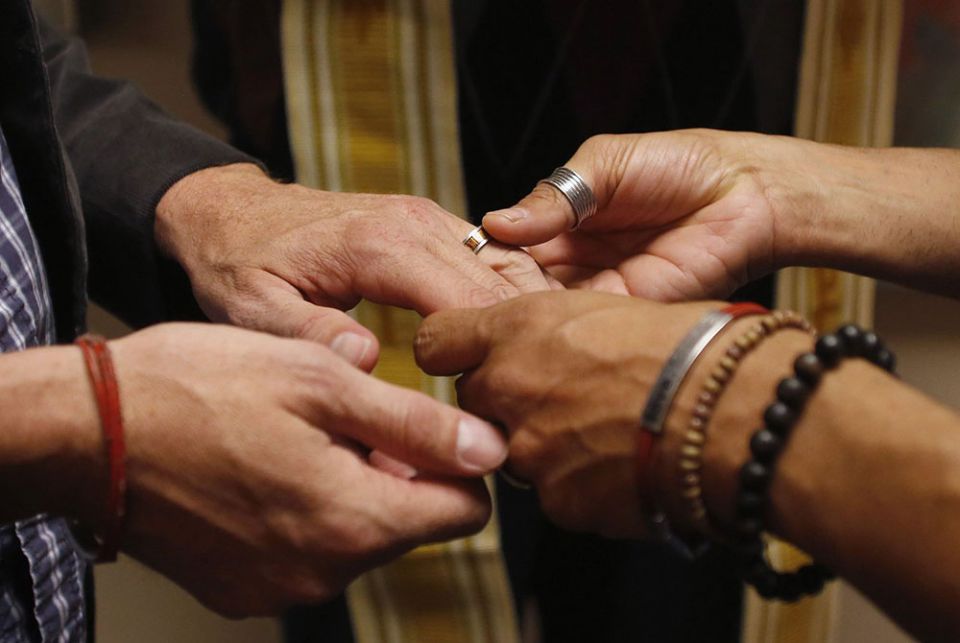 A same-sex couple is pictured in a file photo exchanging rings during a ceremony in Salt Lake City. In a new documentary, Pope Francis expressed openness to the idea of laws recognizing civil unions, including for gay couples, to protect their rights. (CN