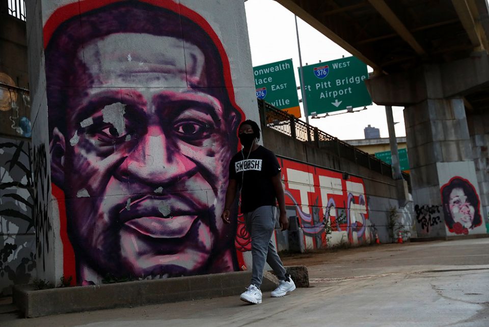 A man in Pittsburgh walks by murals of George Floyd and Breonna Taylor Oct. 21, 2020. (CNS/Shannon Stapleton, Reuters)