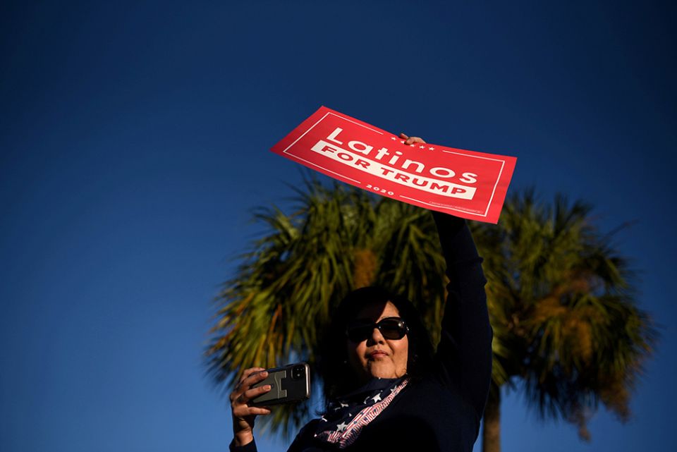 A Latina voter holds up a sign in support of President Donald Trump as voters line up at a polling station on Election Day in Houston Nov. 3. (CNS/Reuters/Callaghan O'Hare)