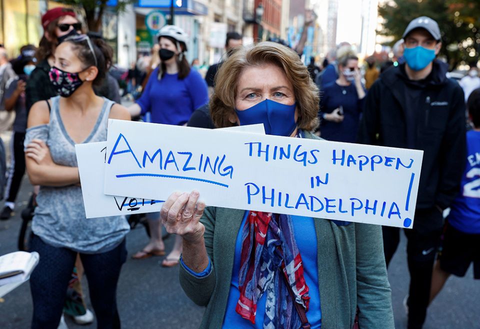 A woman holds a placard in Nov. 7, 2020, in Philadelphia, as media announces that Joe Biden is the presumptive president-elect of the United States, winning the 2020 presidential election. (CNS/Reuters/Rachel Wisniewski)