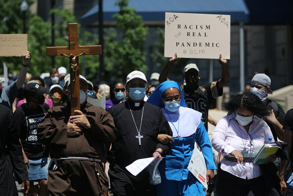 Washington Auxiliary Bishop Roy Campbell and a woman religious walk with others toward the National Museum of African American History and Culture in Washington during a peaceful protest June 8, 2020, following the police killing of George Floyd, an unarm