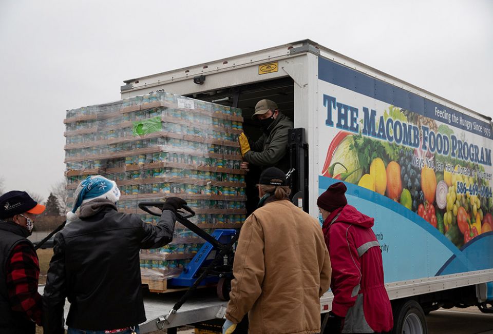 Volunteers from Forgotten Harvest food bank in Warren, Michigan, unload goods before a mobile food pantry distribution Dec. 21, 2020, amid the coronavirus pandemic. (CNS/Reuters/Emily Elconin) Volunteers from Forgotten Harvest food bank in Warren, Michigan, unload goods before a mobile food pantry distribution Dec. 21, 2020, amid the coronavirus pandemic. (CNS/Reuters/Emily Elconin)