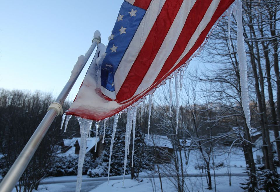 Icicles hang from a frozen U.S. flag on the front porch of a home in Waynesville, North Carolina, Dec. 26, 2020. (CNS/Bob Roller)