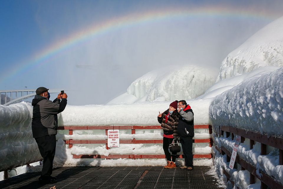 Visitors are photographed at the base of American Falls in Niagara Falls, New York, Feb. 21. (CNS/Reuters/Lindsay DeDario)