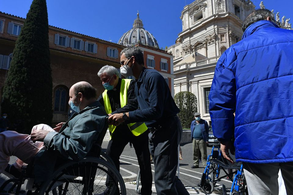 Cardinal Konrad Krajewski, the papal almoner, wears a yellow vest as he assists with a COVID-19 vaccination clinic for the poor at the Vatican March 31. (CNS/Vatican Media)