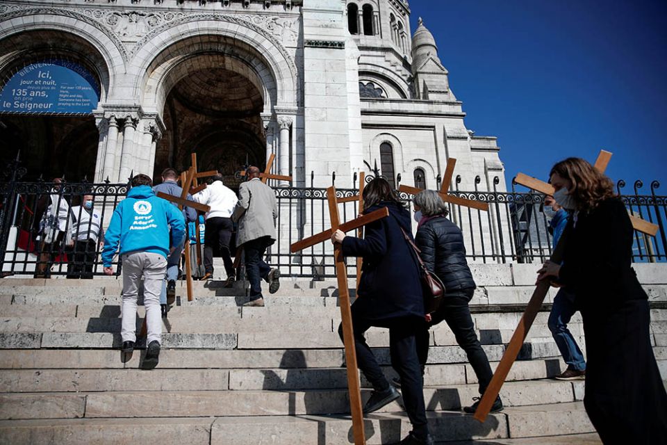 People carry crosses into Sacré-Cœur Basilica on Montmartre in Paris before taking part in a Good Friday procession April 2. (CNS/Reuters/Benoit Tessier)