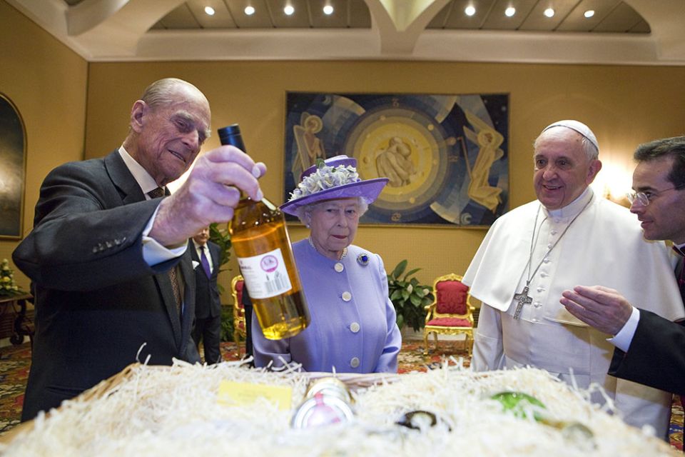 Britain's Prince Philip offers a gift to Pope Francis during a meeting with Queen Elizabeth II at the Vatican April 3, 2014. (CNS/Maria Grazia Picciarella, pool)