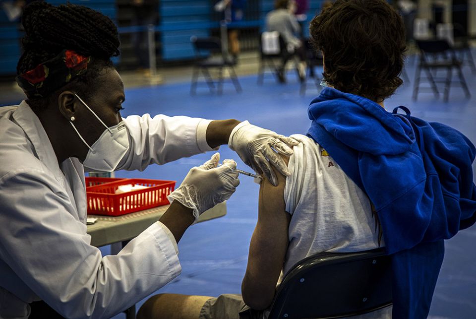 A health care worker administers the Pfizer COVID-19 vaccine to a Marymount University student in one of the athletic buildings on the Catholic college's Arlington, Virginia, campus, during a coronavirus vaccine clinic April 21. (CNS/Chaz Muth)