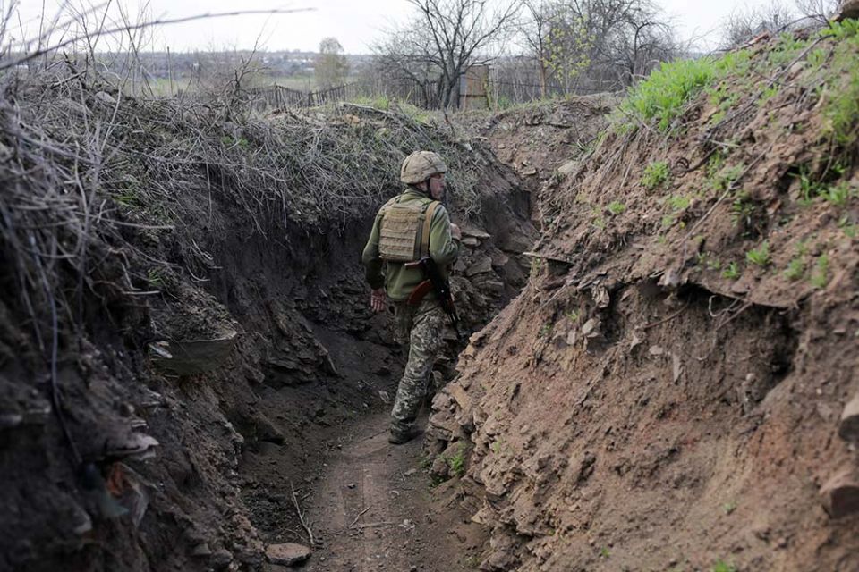 A service member of the Ukrainian armed forces walks at fighting positions on the line of separation near the rebel-controlled city of Donetsk April 26. (CNS/Reuters/Anastasia Vlasova)