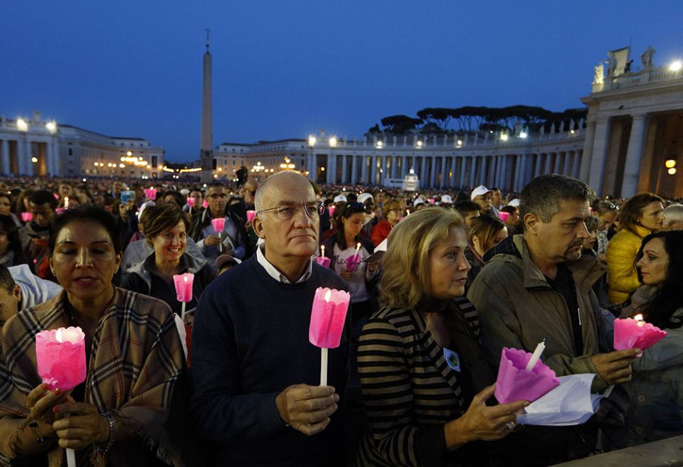 People hold candles during a prayer vigil for the Synod of Bishops on the family attended by Pope Francis in St. Peter's Square at the Vatican Oct. 3, 2015.
