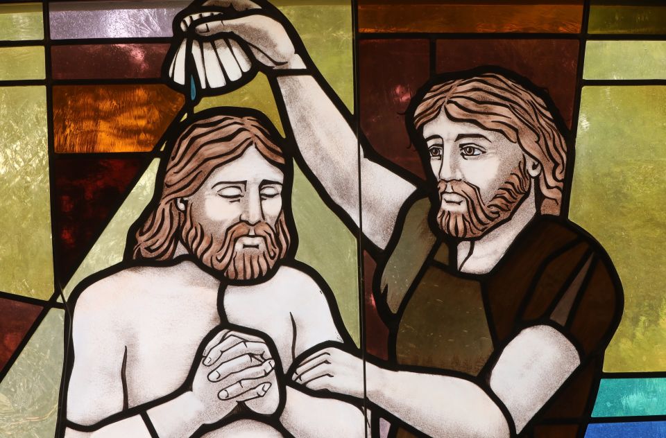 The baptism of Christ by John the Baptist is depicted in a stained-glass window at St. Anthony's Church in North Beach, Md.. July 15, 2021. (CNS photo/Bob Roller)