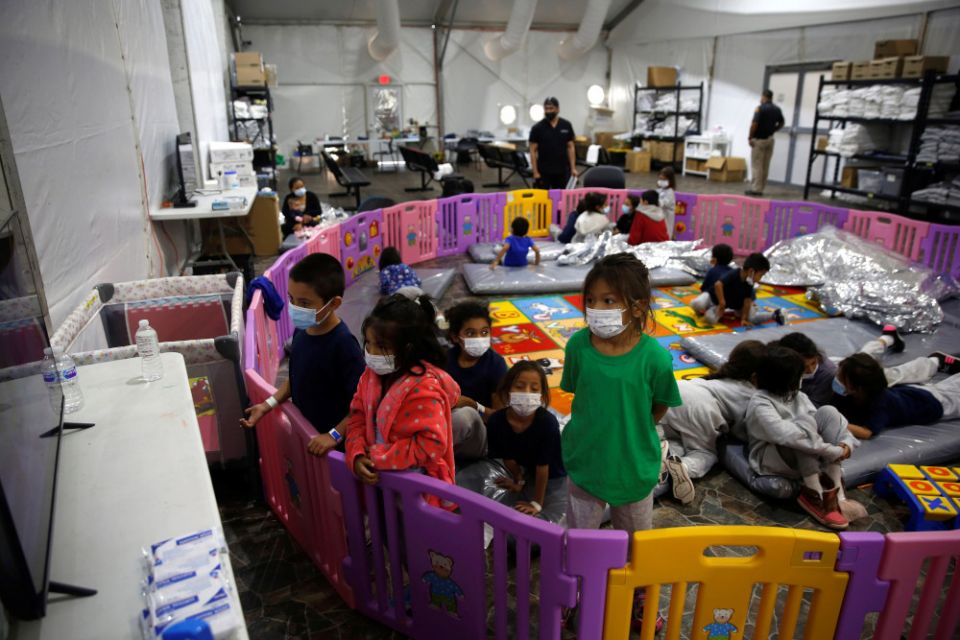 Young unaccompanied migrants, ages 3 to 9, watch television inside a playpen March 30 at the holding facility in Donna, Texas. (CNS/pool via Reuters/Dario Lopez-Mills)