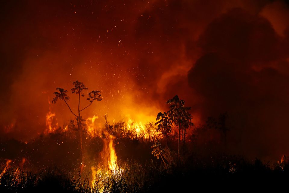 Smoke from a fire in Pocone, Brazil, rises into the air Sept. 3, 2020, as trees burn among vegetation in the Pantanal. (CNS/Reuters/Amanda Perobelli)
