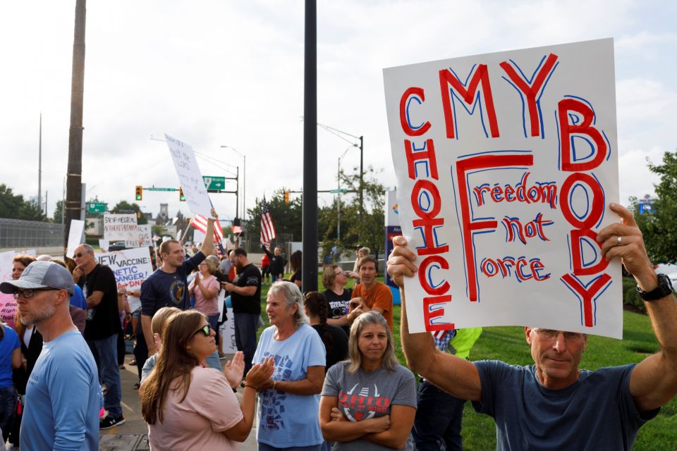 A man holds a sign among a group of people protesting the COVID-19 vaccine mandates at Summa Health Hospital Aug. 16, 2021, in Akron, Ohio. (CNS/Reuters/Stephen Zenner)