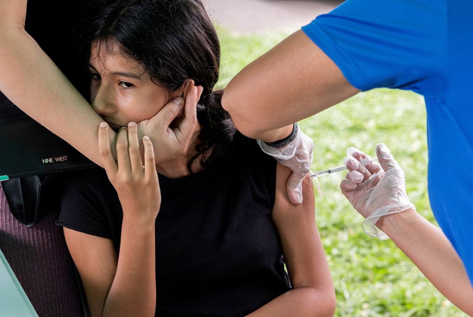 Young person receives the coronavirus vaccine A young person in Bensalem, Pennsylvania, receives the coronavirus vaccine Aug. 22, during an outreach campaign for the Latino community. (CNS/Reuters/Rachel Wisniewski)