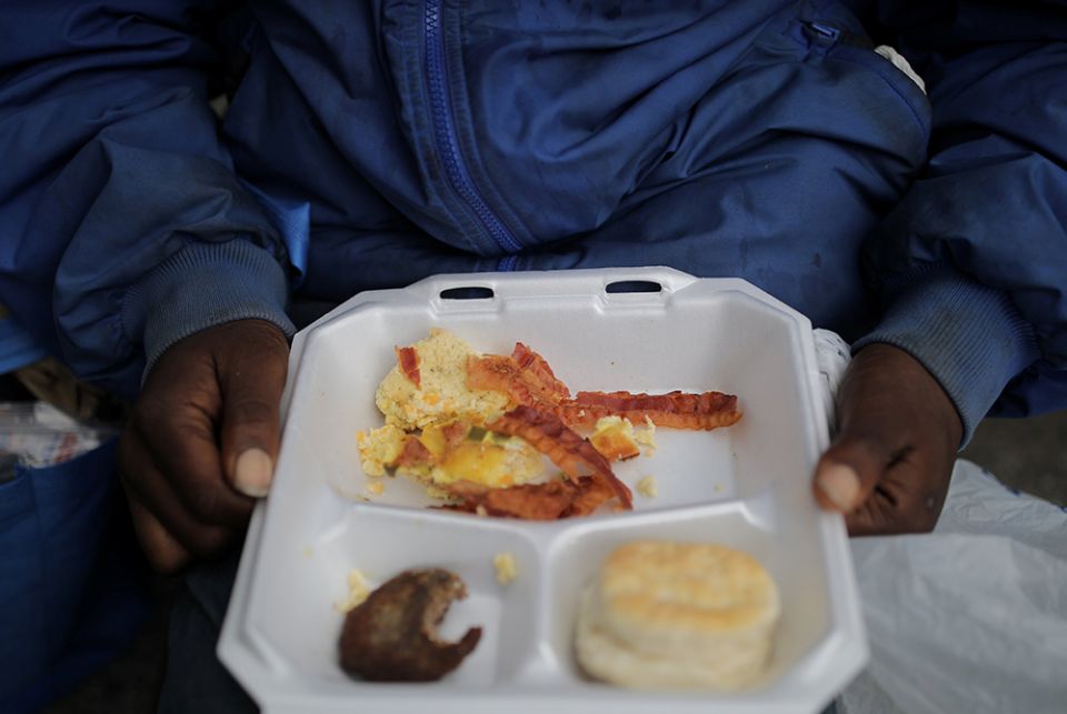 A homeless person in Birmingham, Alabama, eats breakfast during the distribution of food and clothes April 18, 2020. (CNS/Reuters/Carlos Barria)